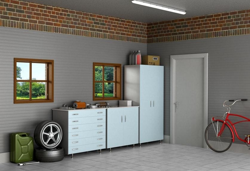 corner of a garage with storage cabinets and a space heater