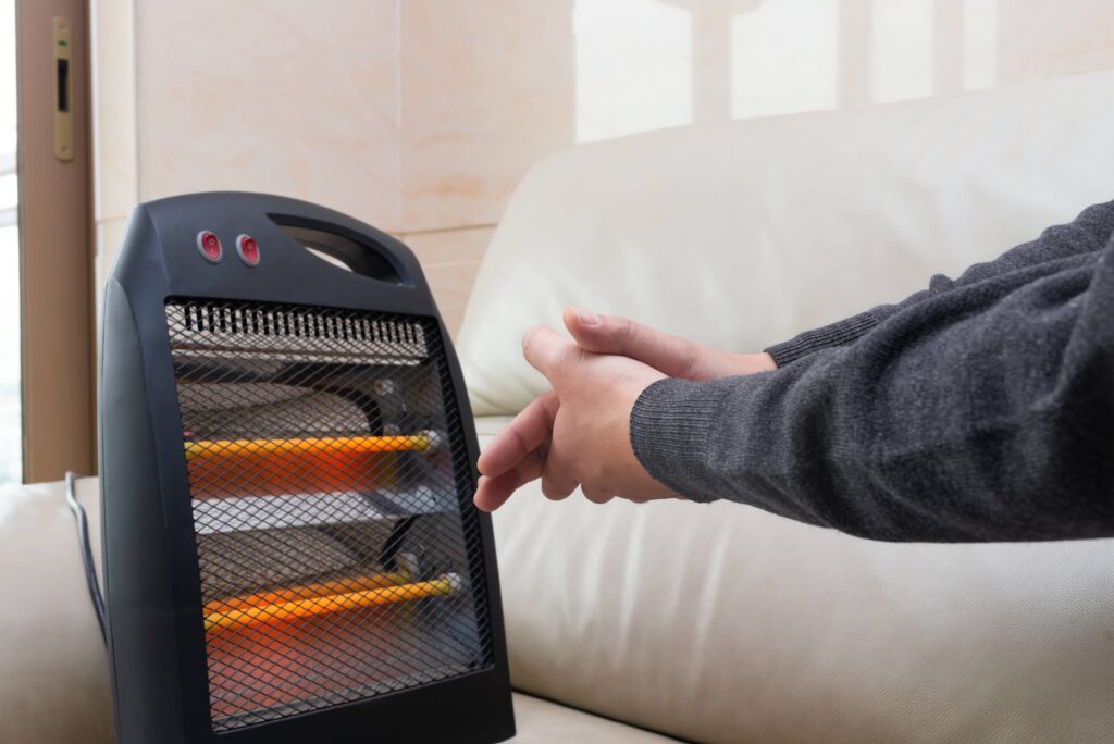 warming hands next to a space heater