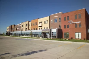 Row of brown, white, and red building with store fronts at the bottom floor - project