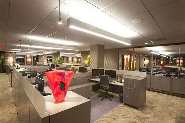 open floor office concept with short cubicles and hanging light bars on the ceiling